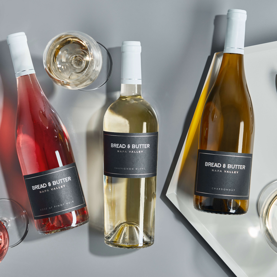 Bread & Butter Napa Valley Collection White Wines on a gray table with glasses poured. From left to right: Napa Valley Rosé, Napa Valley Sauvignon Blanc, Napa Valley Chardonnay.