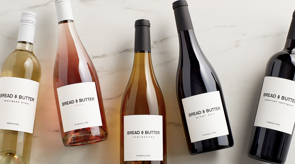 Bread & Butter Everyday Wines on a marble table. From left to right: Sauvignon Blanc, Rose, Chardonnay, Pinot Noir, Cabernet Sauvignon