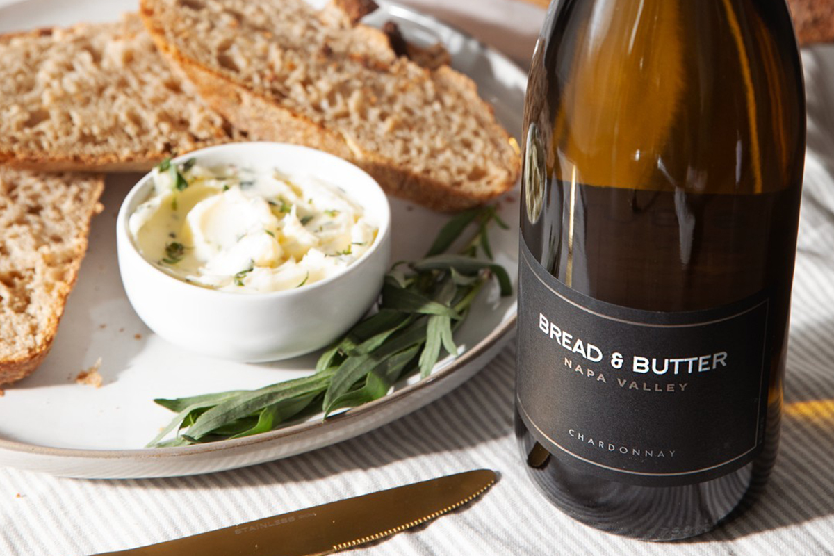 Bread & Butter Napa Valley Chardonnay on a table next to a bowl of Tarragon Butter with slices of toasted bread.