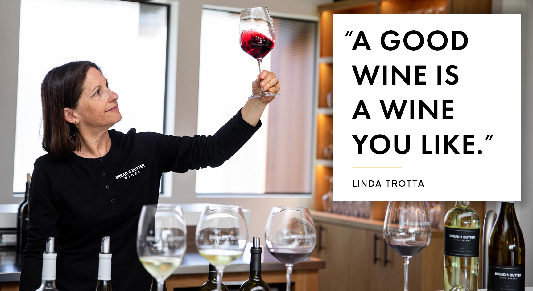 Bread & Butter Winemaker Linda Trotta swirling a glass of red wine in the air at the Bread & Butter Tasting Room in Napa Valley with the quote, "A good wine is a wine you like." – Linda Trotta