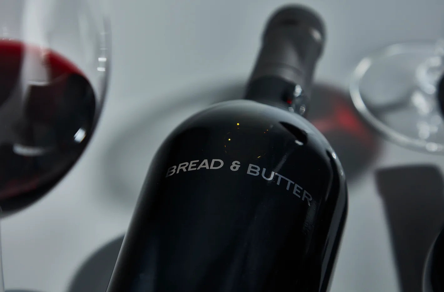 Up close image of cellar collection bottle and glass of wine